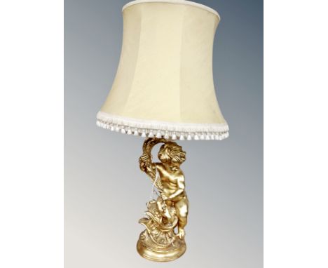 A gilt chalk cherub figural table lamp with tasselled shade  