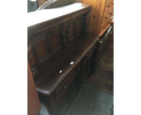 An Ercol dark elm Priory style sideboard. 