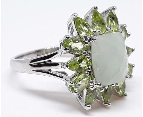 A silver ring set with jade and peridot coloured stones, size U, with box. 