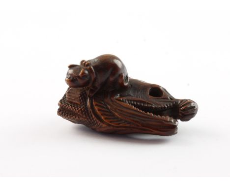 NETSUKE KATZE AUF EINEM FISCHKOPF, Buchsbaum, die katze mit fleckigem Fell und Schleife sitzt auf einem großen Fischkopf, L 4