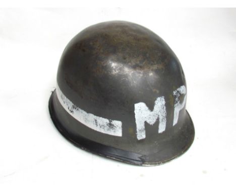 A mid 20th Century US Army helmet with Military Police (MP) lettering, with liner 