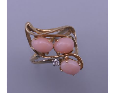 A 14 K gold, coral and diamond ring. 4.4 grammes total weight.