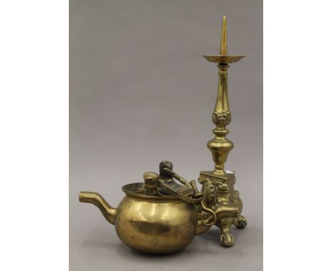 An antique double spouted brass cooking pot with swing handles for suspension and a pricket candlestick. The latter 38 cm hig