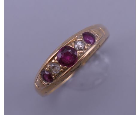 An 18 ct gold ruby and diamond ring. Ring size R/S. 3.9 grammes total weight.