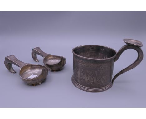 A Russian silver cup (121.4 grammes) and two Russian silver plated kovschs.  Cup 8.5 cm high to top of handle, kovsch 10.5 cm