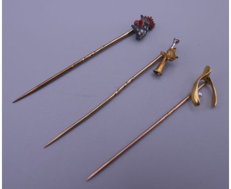 An unmarked fox head and hunting horn stick pin, an unmarked wishbone stick pin and a cockerel head stick pin.  6.5 cm long, 