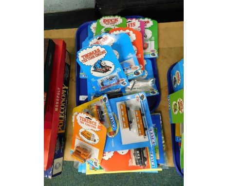 Various Ertl Thomas The Tank Engine blister pack diecast vehicles (1 tray and others) and various board games.  (a quantity)