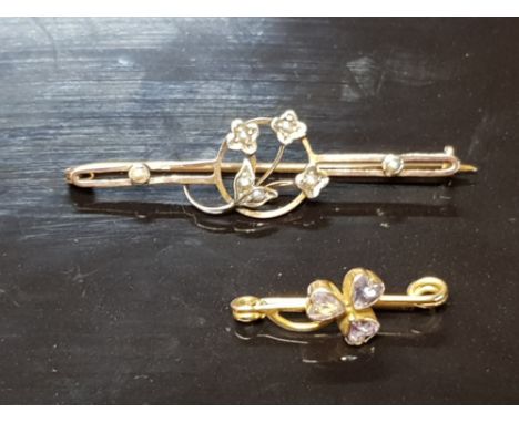 TWO ANTIQUE YELLOW METAL BROOCHES ONE IN THE FORM OF A SHAMROCK WITH PURPLE STONE AND THE OTHER FLORAL AND SEED PEARL 3.7G GR