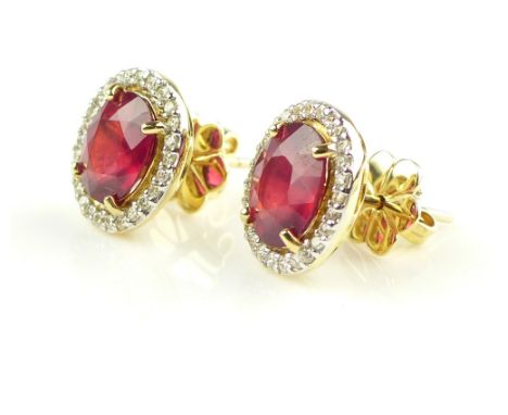 Pair of yellow gold treated ruby and diamond surround earrings, oval form, rubies 4.56ct combined, diamonds 0.37ct combined 