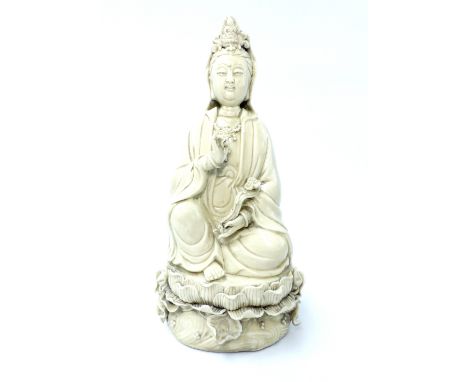 Chinese statue of Guanyin, blanc de Chine, holding a ruyi, seated on a lotus pad, stamps to back