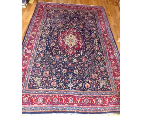 Tabriz carpet, floral design over indigo ground, corresponding red borders, fringed, 356x247cm