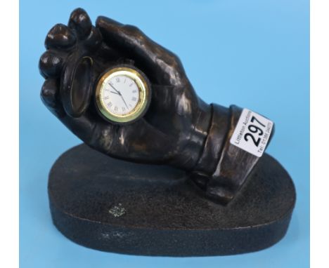 Bronzed hand holding pocket watch