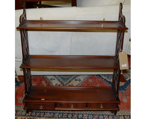 A contemporary Chippendale style mahogany three-tier hanging wall shelf, having three short lower drawers within pierced end 