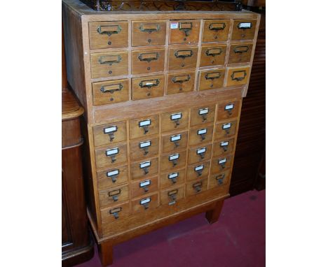An early 20th century light oak office filing chest comprised of two sections fitted with forty drawers, width 83cm