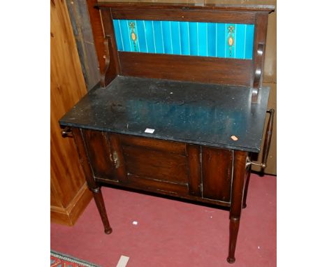 An early 20th century oak black marble and tile inset single door wash stand having end carry handles, width 83.5cm