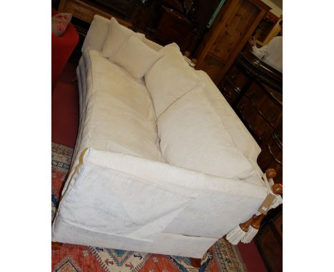 A large contemporary Duresta Horatio four-seater sofa, with curved front, cream upholstery, walnut finials and supports, w.24