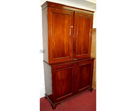 A mahogany four door side cupboard, the plain recessed panelled doors raised on straight bracket supports, width 122cm