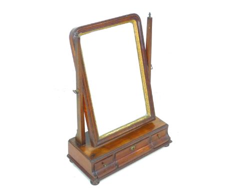 A George III mahogany toilet mirror, the rectangular plate with moulded frame and gilt slip, the base outswept to lower edge 