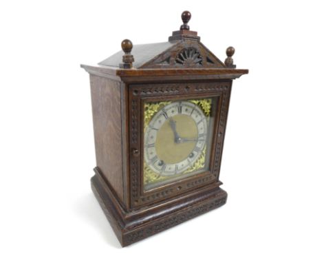 An oak cased mantel clock, glass fronted with silvered chapter ring, black Roman numerals and applied gilt spandrels, eight d