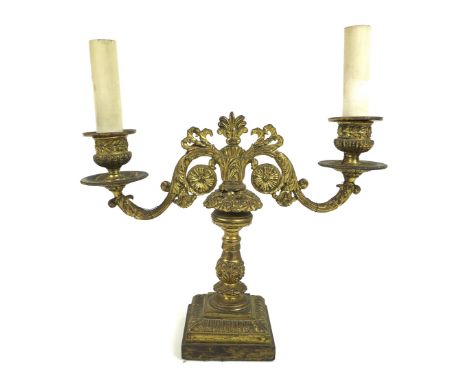 A French late 19th century gilt metal twin branch table lamp, with floral scrolling decoration and candle effect lamp holders