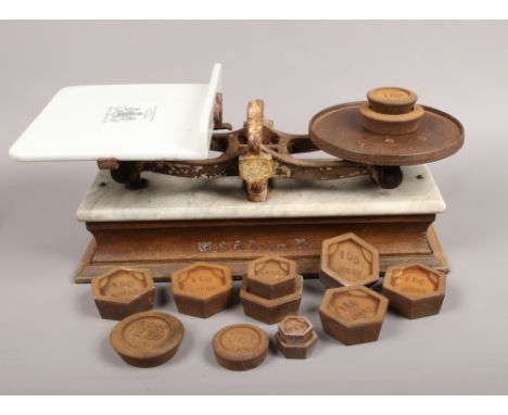 A set of Edwardian cast iron and ceramic scales by W &amp; T Avery Limited with a collection of weights.
