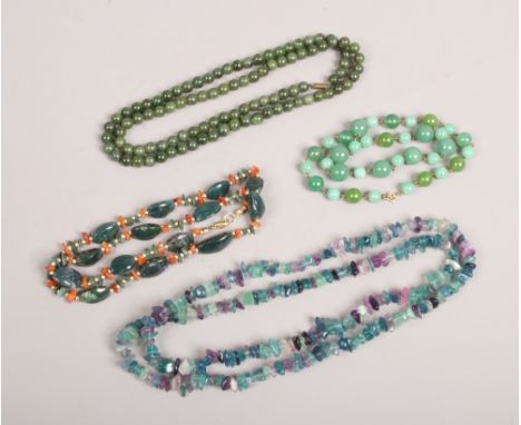 A tray of polished hardstone necklaces including jade coloured examples.