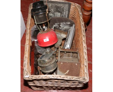 A wicker basket and contents of metalwares including Tilly lamp, bell , crank etc.