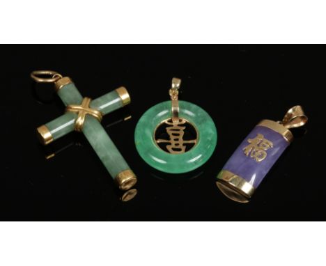 A gold mounted jade crucifix pendant and two 9ct gold mounted Chinese jade pendants ornamented with Shou characters, one lave