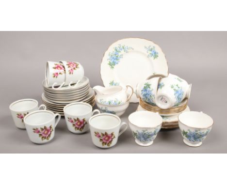 A Queen Anne bone china six place tea service along with a German made service decortaed with flowers.