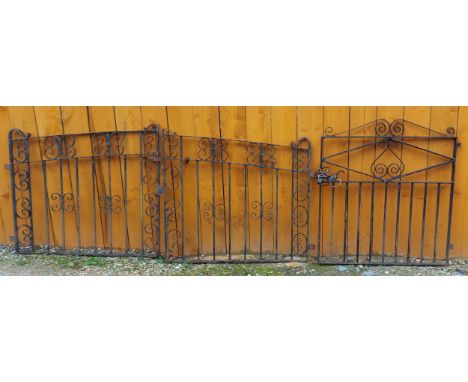 A pair of iron gates of scroll form, 105cms tall, both gates together 235cms wide together with another single iron gate, 113