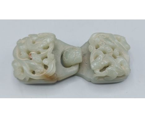 A Chinese Jade belt buckle of carved pierced form, 10.5cms long 