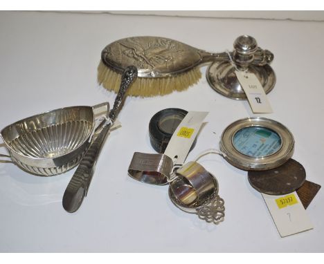 A Middle Eastern silver dwarf candlestick; a silver mounted dressing table hand brush embossed with an angel; a silver mounte