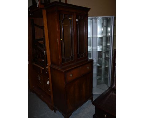 A reproduction inlaid mahogany Georgian style secretaire bookcase, with glazed cupboard doors, raised on bracket feet.