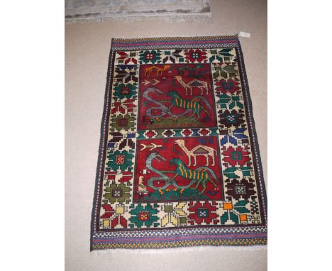 A hunting Herathi rug decorated with animals and stylized foliate design.