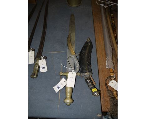 An ornamental dagger; a kukri; and a sword with brass handle.