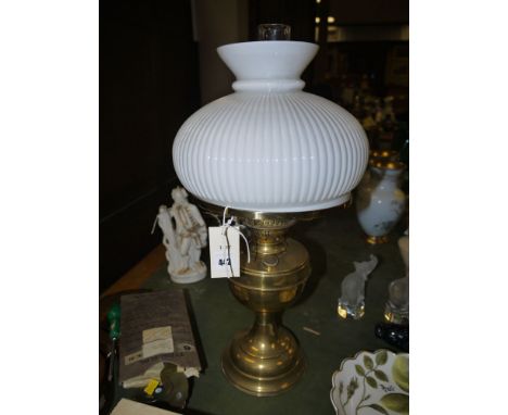 A brass oil lamp with glass shade.