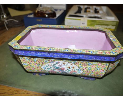 A cloisonne planter decorated with flowers and peacocks.