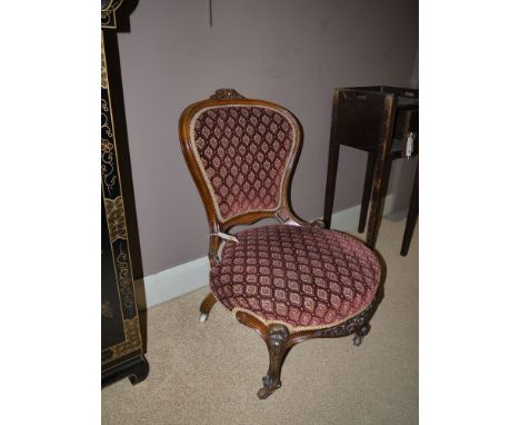 A pair of Victorian carved and stained mahogany occasional chairs, with balloon shape backs and circular seats, the exposed f
