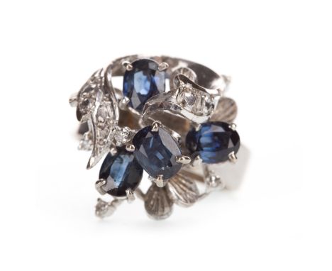 BLUE GEM AND DIAMOND COCKTAIL RING, the high set bezel set with four oval faceted blue gems, each approximately 5.5mm long an