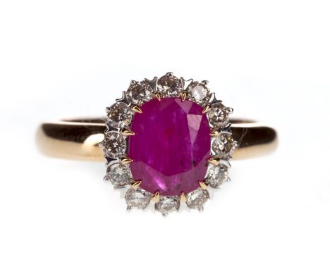 RUBY AND DIAMOND RING, the cushion shaped ruby within a round brilliant cut diamond halo, the diamonds totalling approximatel
