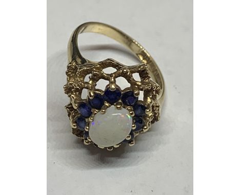 A MARKED 9 CARAT GOLD RING WITH A CENTRAL OPAL SURROUNDED BY TEN SAPPHIRES SIZE P WITH A PRESENTATION BOX GROSS WEIGHT 4.6 GR