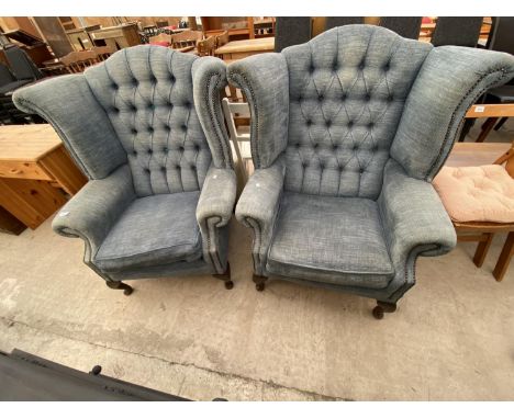 A PAIR OF WINGED AND BUTTON-BACK FIRESIDE CHAIRS ON CABRIOLE LEGS 