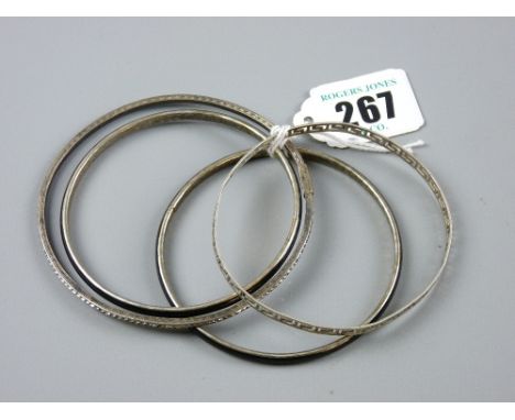 Two white metal bangles and two black enamel and white metal bangles