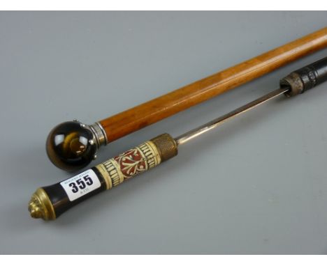 A malacca gentleman's cane with white metal crown shaped top holding a tiger's eye ball grip with a possibly Indian ebony and