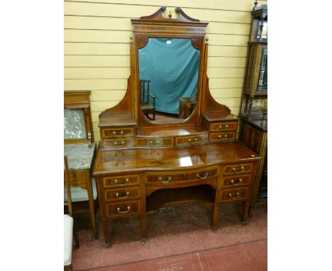 A top quality Edwardian inlaid mahogany dressing table, the mirror with broken swan neck pediment and carved urn finial, bras