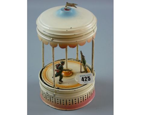 A vintage tinplate clockwork musical carousel with tinplate figures (one missing), 24 cms high
