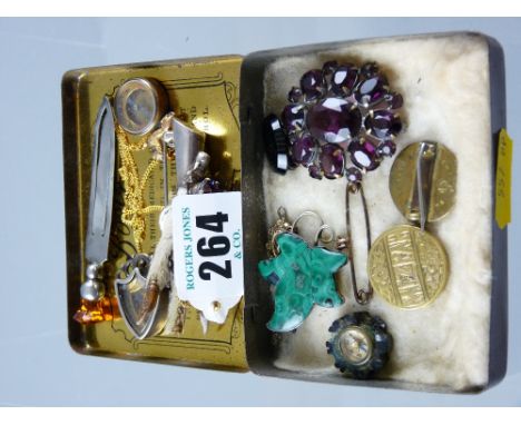 A silver claw brooch with thistle mounted precious stone, a silver menu holder with precious stones to handle, a nine carat g