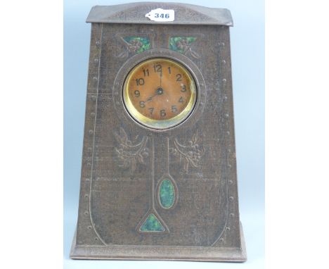 An Art Nouveau biscuit/sweet clock tin with embossed rivet edging, stylized floral pattern with pseudo enamel panels (unknown