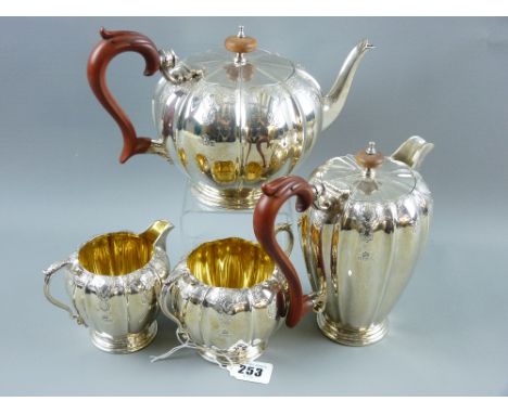 An attractive heavy four piece silver tea and coffee service, each piece of neat proportions with decorative scaling and scro