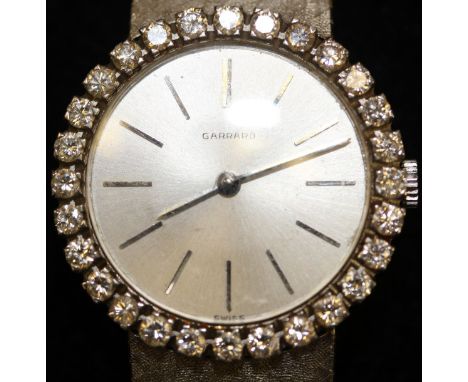 A mid 20th Century Garrard's ladies wristwatch, the enamel dial set with Roman numerals surrounded by a mount of 28 brilliant
